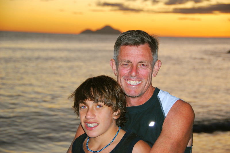 Image of Warwick and his late sone, Harrison in a beach background with beautiful sunset skies.