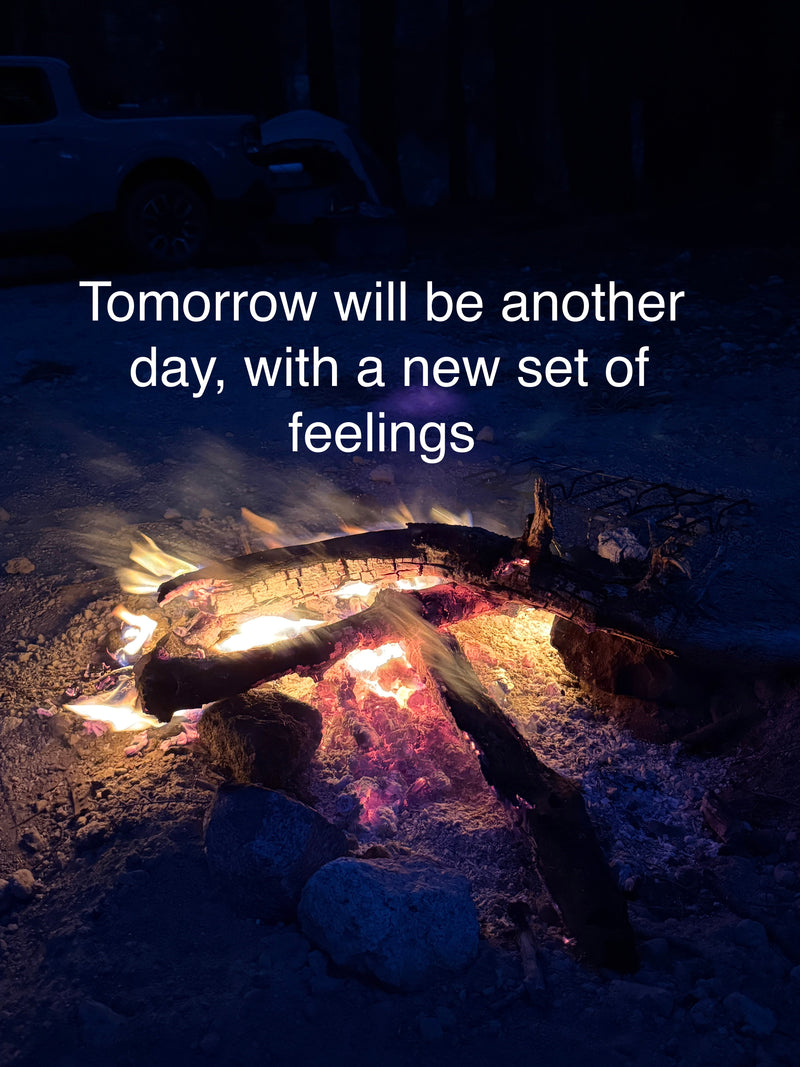 Fire pit with glowing embers and text overlay 'Tomorrow will be another day, with a new set of feelings' on a dark background.